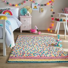 a child's bedroom decorated in pastel colors with toys on the floor and rug