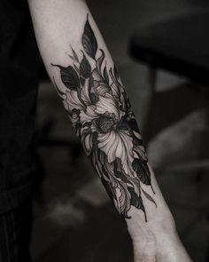 a woman's arm with a flower tattoo on it