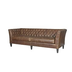 a brown leather couch sitting on top of a white wall