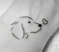 a dog's head with a heart tattoo on the wrist is shown in black ink