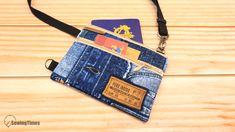 a wallet with two credit cards in it on a wooden table next to a lanyard