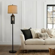 a living room filled with furniture and a lamp on top of a wooden coffee table