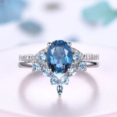 a ring with an oval blue topaz surrounded by smaller light blue and white diamonds