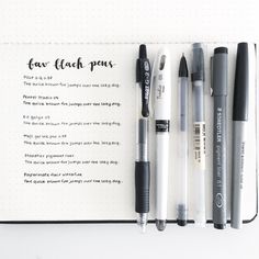 some pens are laying on top of an open notebook with the words fax - black pens written in it