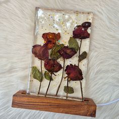 some flowers are in a glass block on a white furnishing area with gold flecks