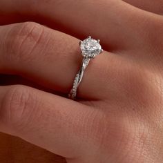 a woman's hand with a diamond ring on top of her finger and an engagement band