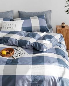 a blue and white checkered comforter set on a bed with two pillow cases