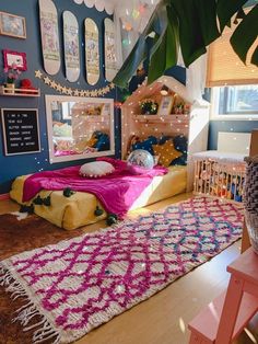 a bedroom decorated in pink, yellow and blue with a large rug on the floor