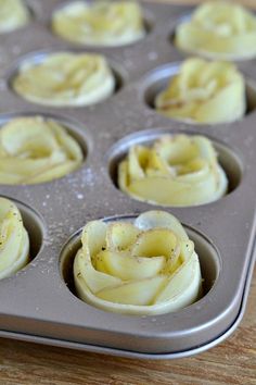 an uncooked muffin tin filled with cupcakes on top of a wooden table