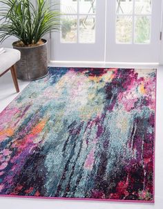 a colorful area rug in front of a door with potted plants on the side