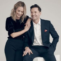 a man sitting next to a woman in a black suit