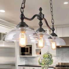 three lights hanging from the ceiling in a kitchen