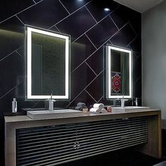 a bathroom with two sinks, mirrors and lights on the wall above it's counter