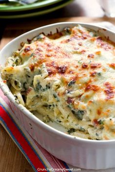 a casserole dish with spinach and cheese in it on a wooden table