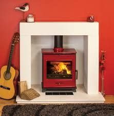 a red stove sitting in the corner of a room next to a guitar and fireplace