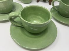 the green cups and saucers are on the table