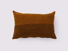 a brown and black striped pillow on a white background with the same color as it appears