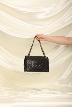 CONDITION: GOOD VINTAGE .??¨ Crafted from the finest lambskin leather, this medium classic flap features the Chanel signature quilted pattern. The sleek black color is versatile and perfect for any occasion, while the 24K gold plated hardware adds a touch of luxury and elegance. The spacious interior of this flap bag features multiple compartments, allowing you to keep all of your essentials organized and easily accessible. The adjustable chain strap can be as a single or double strap, giving you the flexibility to wear it as a shoulder bag or crossbody. This classic flap is a true investment piece you won't regret, and will never go out of style. It's the perfect accessory to elevate any outfit and add a touch of sophistication to your everyday look. Crafted in 1989-1991 9.5" L x 2.5 " W Signature Quilts, Hermes Shoes, Fendi Shoes, Bottega Veneta Shoulder Bag, Louis Vuitton Shoes, Chanel Shoes, Dior Shoes, Flap Bag, Lambskin Leather