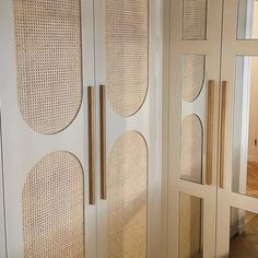 a room with some white cupboards and mirrors on the wall next to each other