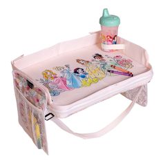 a pink baby changing table with princess pictures on it and a bottle in the middle