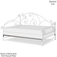 the bed frame is white and has scroll designs on it, as well as an iron headboard