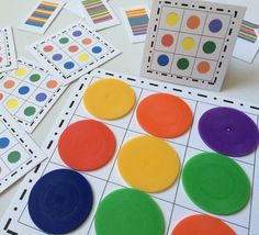 several different colored circles and numbers are on the table with matching cards to match them