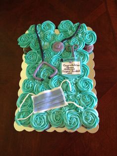 a cupcake cake that is shaped like a nurse's hat and stethoscope