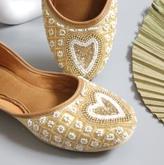 Bring your wardrobe to life with the Levi golden beige ballerina. This jutti shoe features gold and white pearl embellishments with dabka work, for a sophisticated style that will become the staple of your closet. With a careful construction, the Levi golden beige Ballerina is designed to be comfortable and durable. All embellishment is hand crafted.  Upper: Silk Insole - Synthetic Sole - TC Dabka & Pearl Work Embroidered We try to take pictures as normal as we can but Colors may vary due to light setup. Pakistani Khussa, Dabka Work, Indian Shoes, Pearl Work, Punjabi Jutti, Ear Chain, Head Chain, Gold Plated Bangles, Authentic Indian