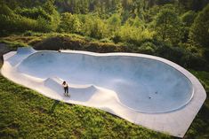 a skateboarder is standing in the middle of an empty swimming pool that looks like it has been made from concrete