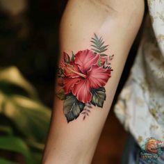 a woman's arm with a red flower tattoo on the left side of her arm