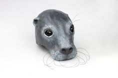 an animal head made out of metal on a white surface with black eyes and nose