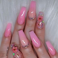 a woman's hand with pink nail polish and flowers on the tip of her nails