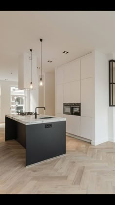 an image of a kitchen with white cabinets and black counter tops on the right side