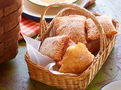 a basket filled with pastries sitting on top of a table next to a plate