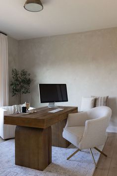 a desk with a computer on it and two chairs in front of the monitor screen