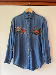 Vintage 90's Embroidered Autumnal Themed button up denim long sleeve shirt. Adorable Fall harvest and pumpkins. Love the red bird sitting on the fence. In good vintage condition. Showing signs of normal age, wash and wear. Some loose threads in the embroidery.  So CUTE!  Measurements taken while item was laying flat. Marked size S.  Pit to pit: 21" Length: 28" Fall Medium Wash Tops With Floral Embroidery, Fall Medium Wash Top With Floral Embroidery, Medium Wash Floral Embroidery Top For Fall, Medium Wash Floral Embroidered Tops For Fall, Fall Embroidered Denim Tops, Embroidered Denim Tops For Fall, Embroidered Denim Shirt, Bird Sitting, Denim Embroidery