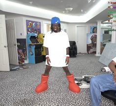 a young man wearing orange boots and a blue hat