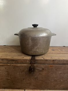 an old metal pot sitting on top of a wooden box