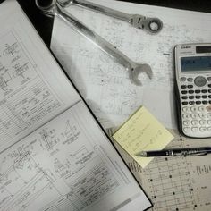 a calculator, wrench, and other tools on top of construction plans