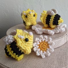 three crocheted bees sitting on top of a table