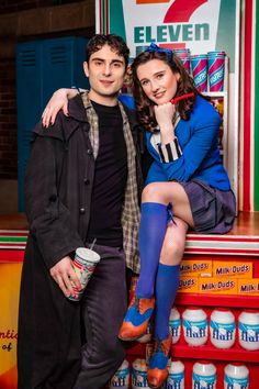 a man and woman posing for a photo in front of a vending machine