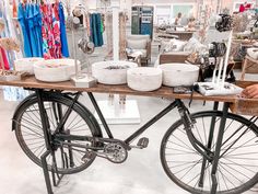 a bicycle parked in front of a table with baskets on it