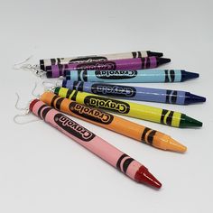 four crayons are lined up in the shape of a keychain,