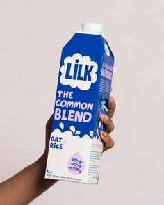 a person holding up a carton of milk