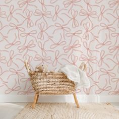 a wicker basket with stuffed animals in front of a pink wallpaper