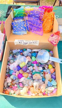 a cardboard box filled with lots of different colored rocks and stones on top of a table