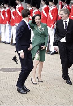 a man in a suit and tie standing next to a woman in a green dress