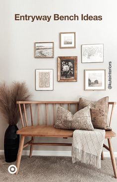 a wooden bench sitting in front of a wall with pictures on the wall above it