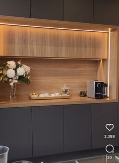 a vase with white flowers sitting on top of a counter next to a coffee maker