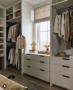 an organized closet with clothes and shoes on the shelves, along with a bed in the foreground